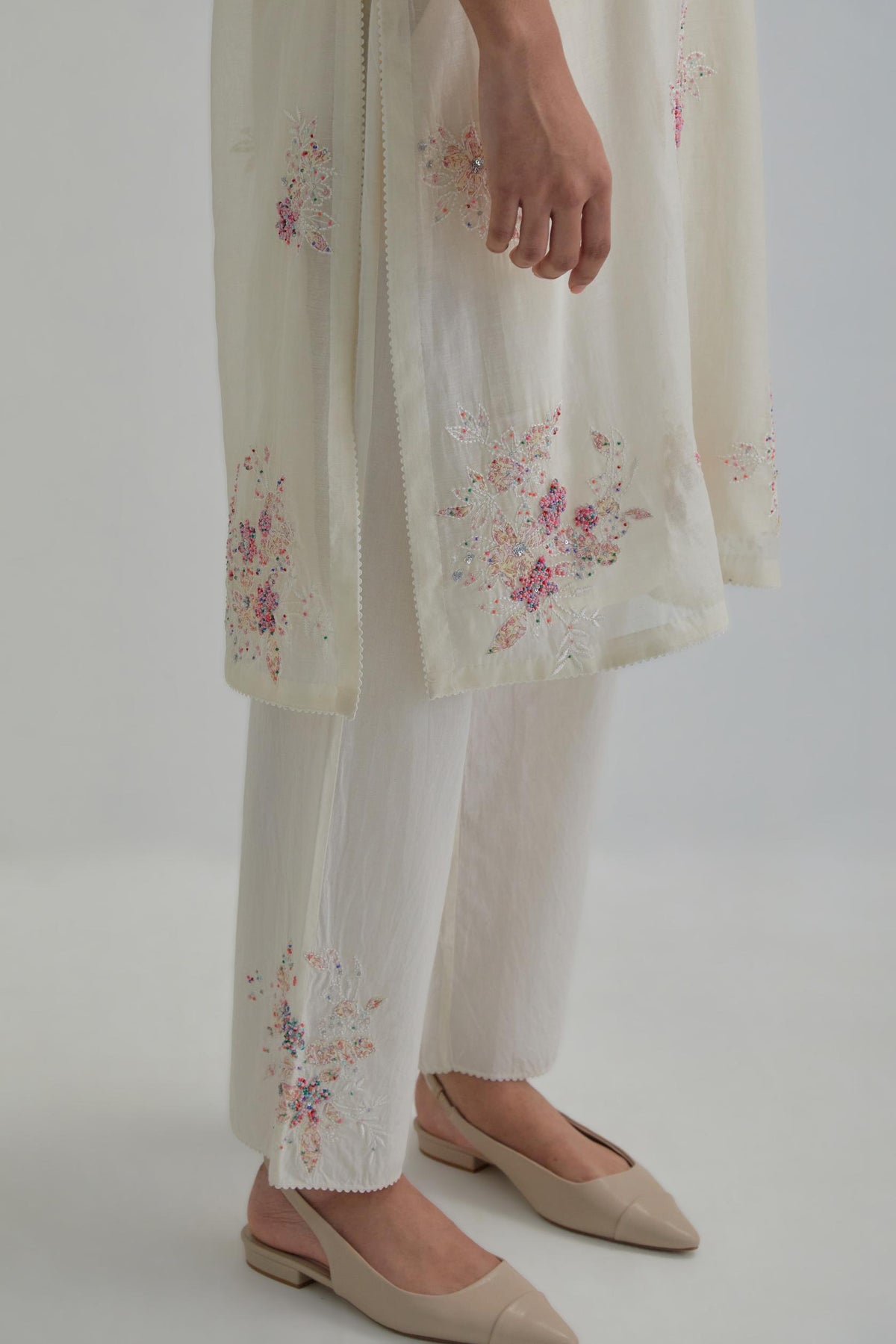 Off white straight short kurta set with all-over pink & beige hand block printed appliqué motifs, highlighted with sequins and multi coloured beads.