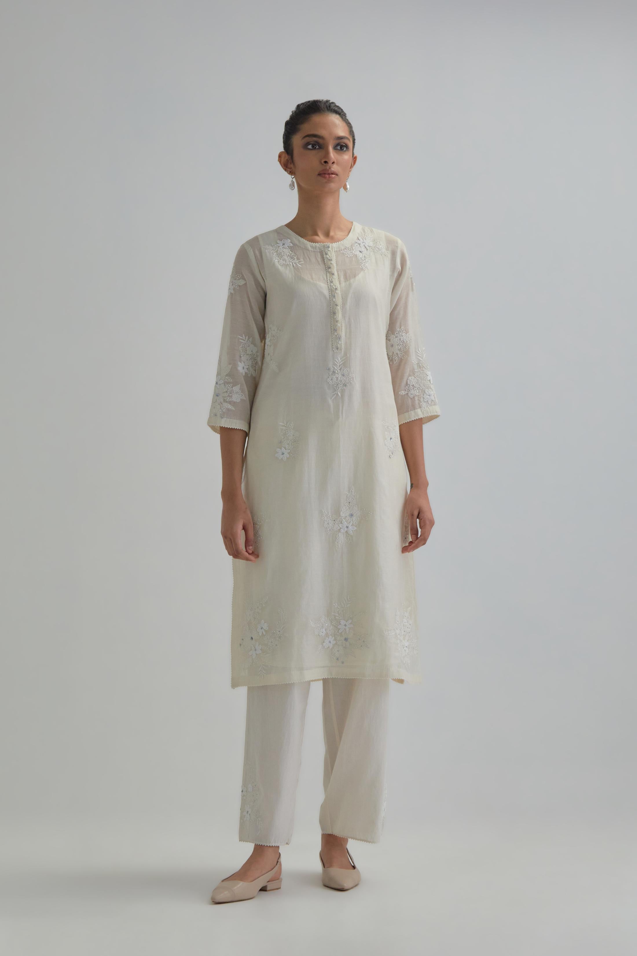 Off white straight short kurta set with all-over appliqué motifs, highlighted with sequins and beads.