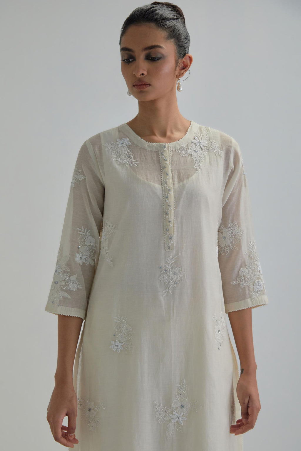 Off white straight short kurta set with all-over appliqué motifs, highlighted with sequins and beads.