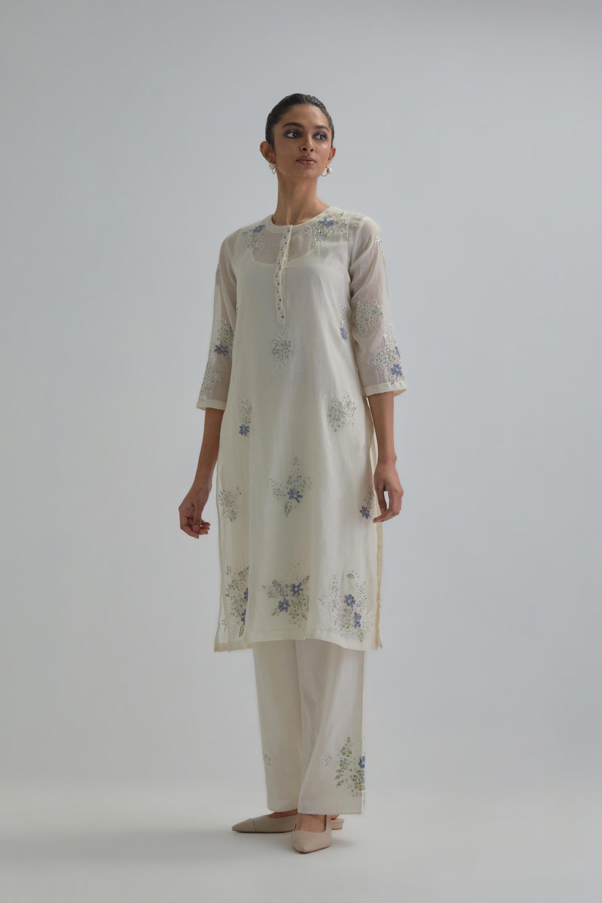 Off white straight short kurta set with all-over blue & beige hand block printed appliqué motifs, highlighted with sequins and multi coloured beads.