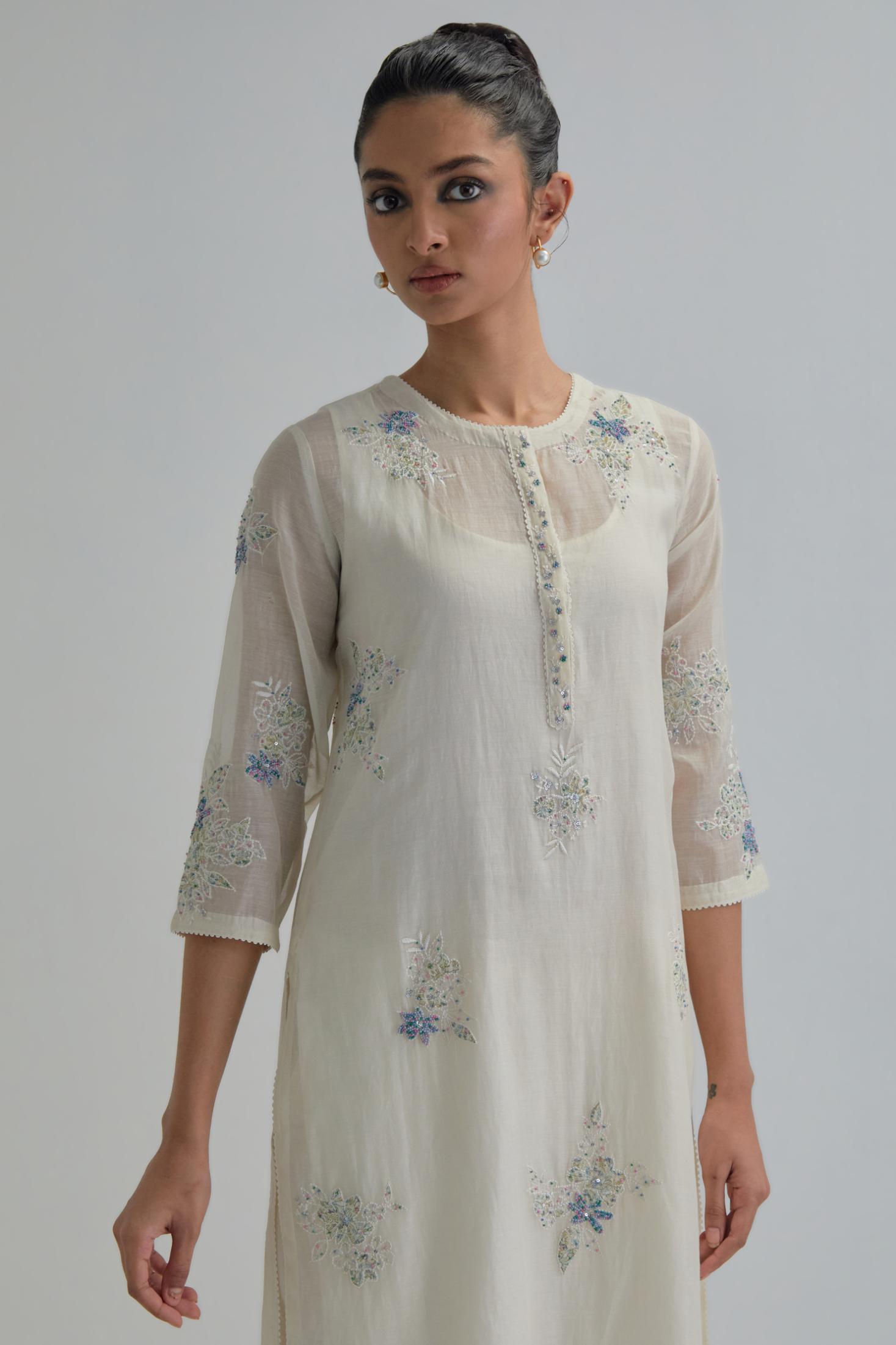 Off white straight short kurta set with all-over blue & beige hand block printed appliqué motifs, highlighted with sequins and multi coloured beads.