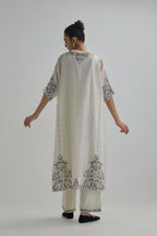 Off white Silk Chanderi easy fit kaftan with earthy coloured thread Aari embroidery, highlighted with silver sequins work, paired with Off white silk Chanderi straight pants with earthy coloured Aari work at hem.