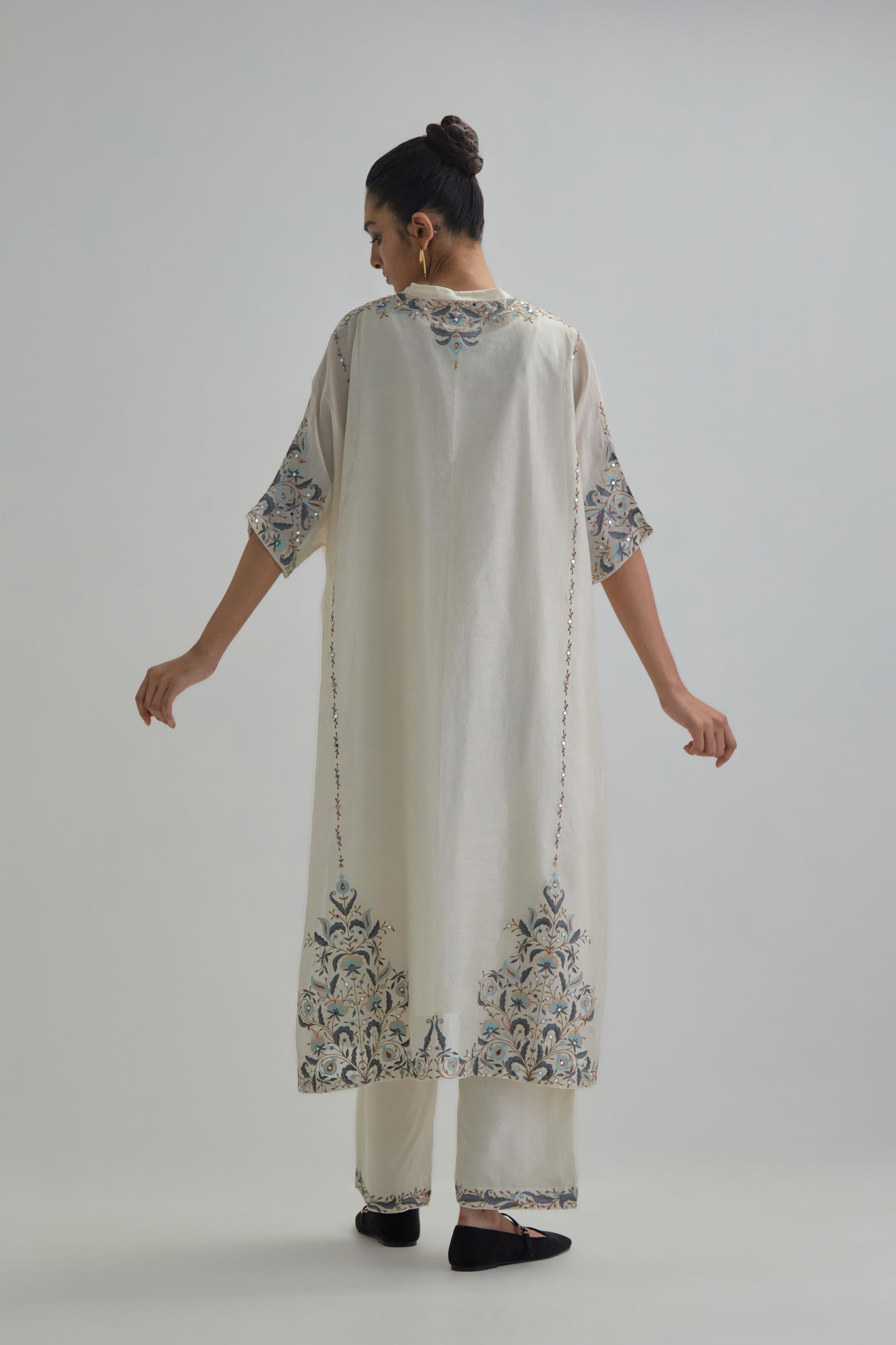 Off white Silk Chanderi easy fit kaftan with earthy coloured thread Aari embroidery, highlighted with silver sequins work, paired with Off white silk Chanderi straight pants with earthy coloured Aari work at hem.