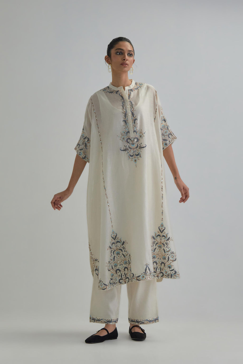 Off white Silk Chanderi easy fit kaftan with earthy coloured thread Aari embroidery, highlighted with silver sequins work, paired with Off white silk Chanderi straight pants with earthy coloured Aari work at hem.