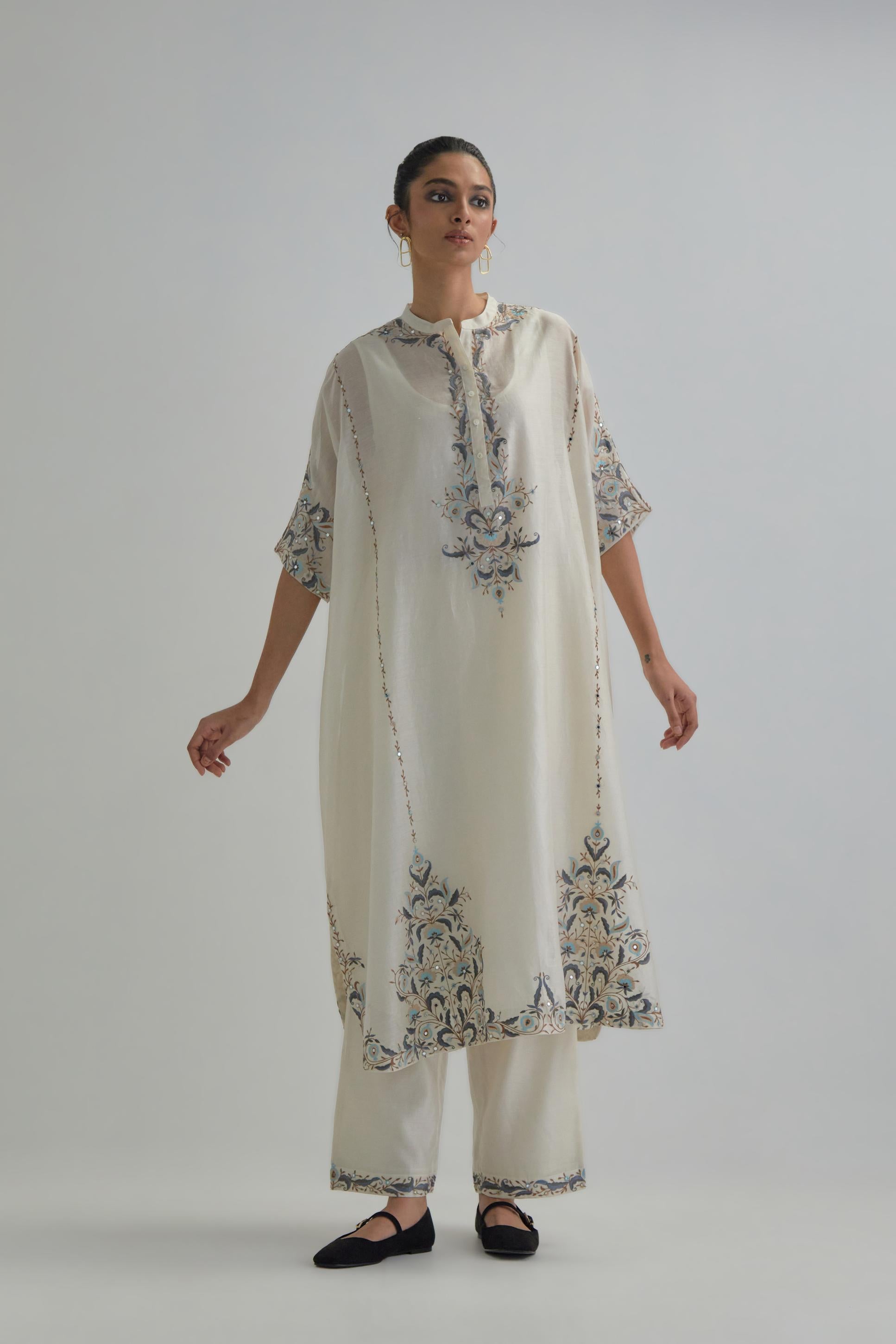 Off white Silk Chanderi easy fit kaftan with earthy coloured thread Aari embroidery, highlighted with silver sequins work, paired with Off white silk Chanderi straight pants with earthy coloured Aari work at hem.