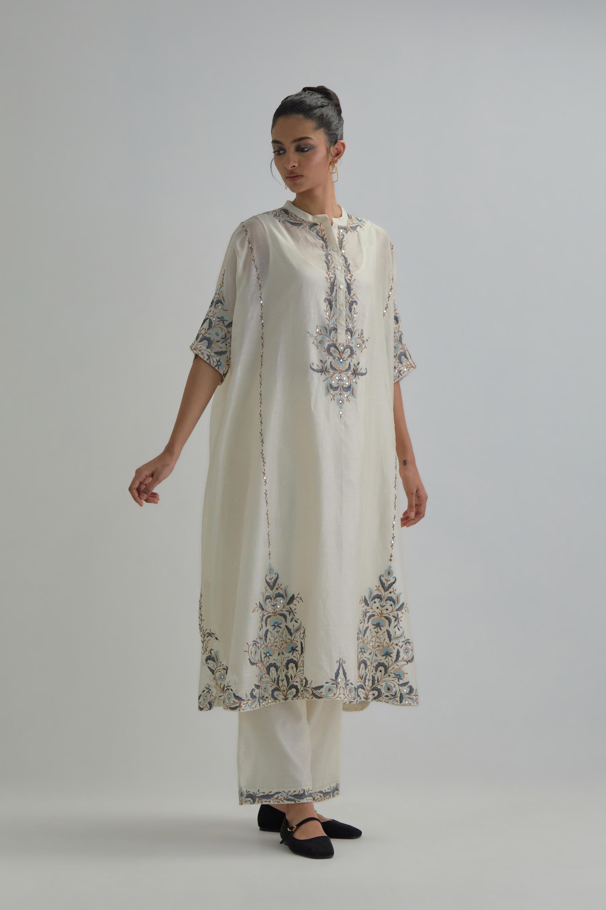 Off white Silk Chanderi easy fit kaftan with earthy coloured thread Aari embroidery, highlighted with silver sequins work, paired with Off white silk Chanderi straight pants with earthy coloured Aari work at hem.