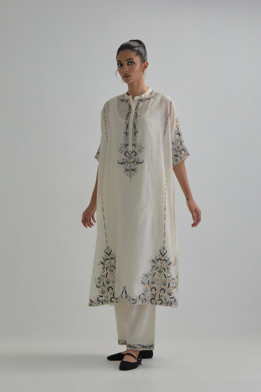 Off white Silk Chanderi easy fit kaftan with earthy coloured thread Aari embroidery, highlighted with silver sequins work, paired with Off white silk Chanderi straight pants with earthy coloured Aari work at hem.