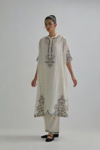 Off white Silk Chanderi easy fit kaftan with earthy coloured thread Aari embroidery, highlighted with silver sequins work, paired with Off white silk Chanderi straight pants with earthy coloured Aari work at hem.