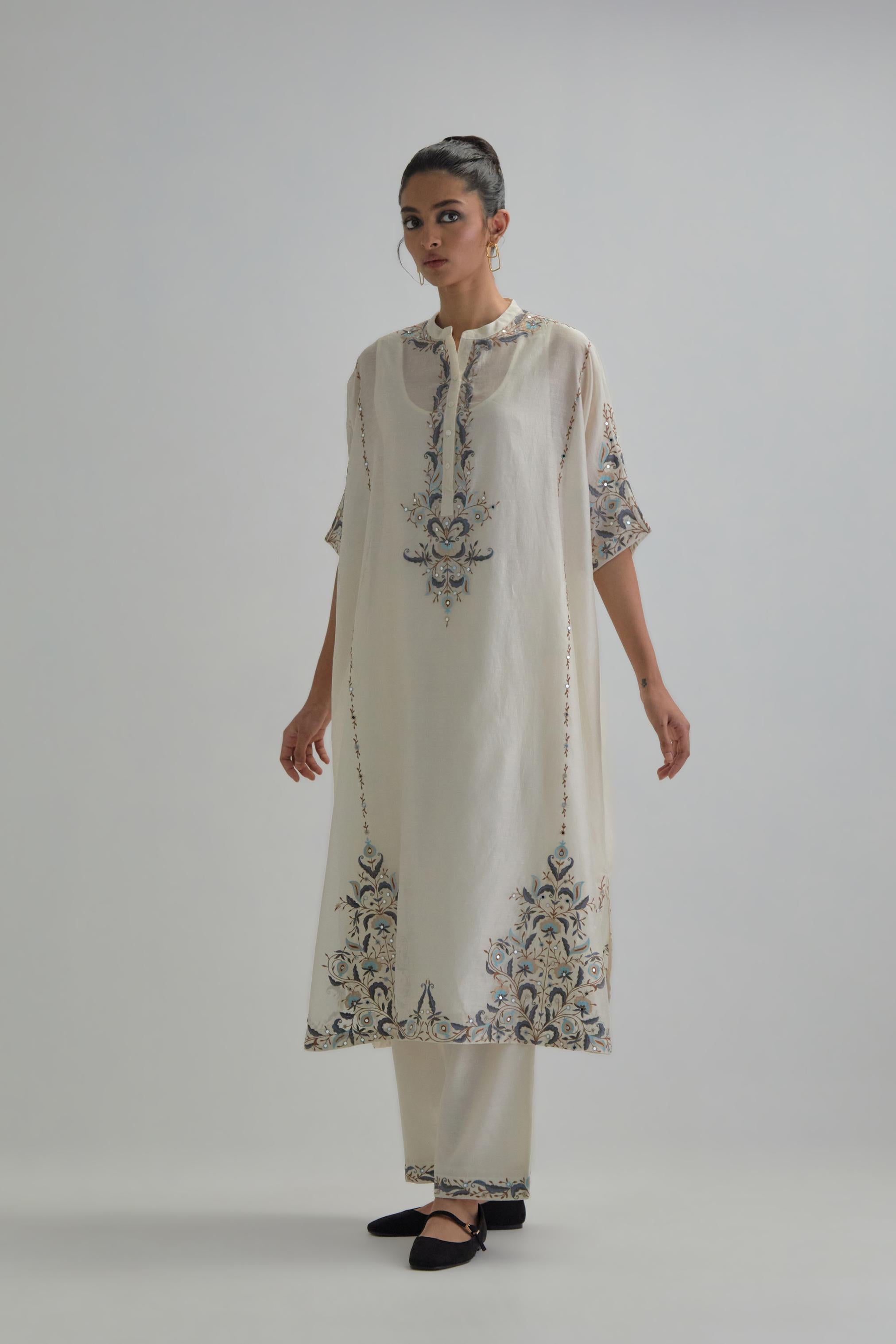 Off white Silk Chanderi easy fit kaftan with earthy coloured thread Aari embroidery, highlighted with silver sequins work, paired with Off white silk Chanderi straight pants with earthy coloured Aari work at hem.