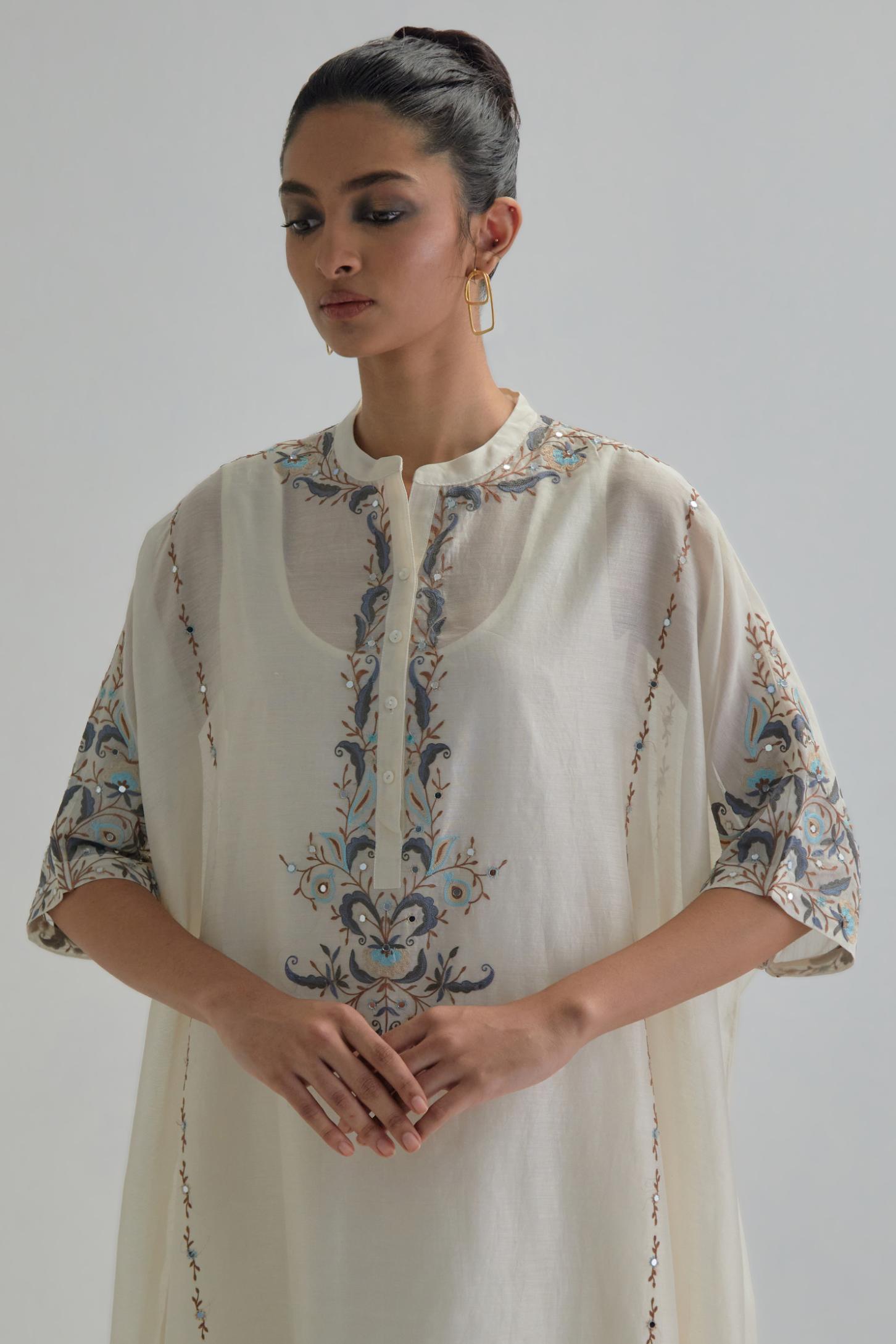 Off white Silk Chanderi easy fit kaftan with earthy coloured thread Aari embroidery, highlighted with silver sequins work, paired with Off white silk Chanderi straight pants with earthy coloured Aari work at hem.