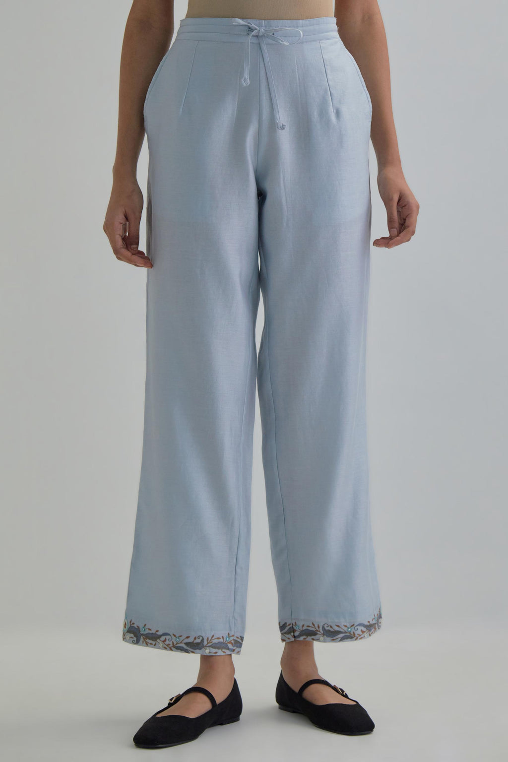 Blue silk Chanderi straight pants with earthy coloured Aari work at hem.