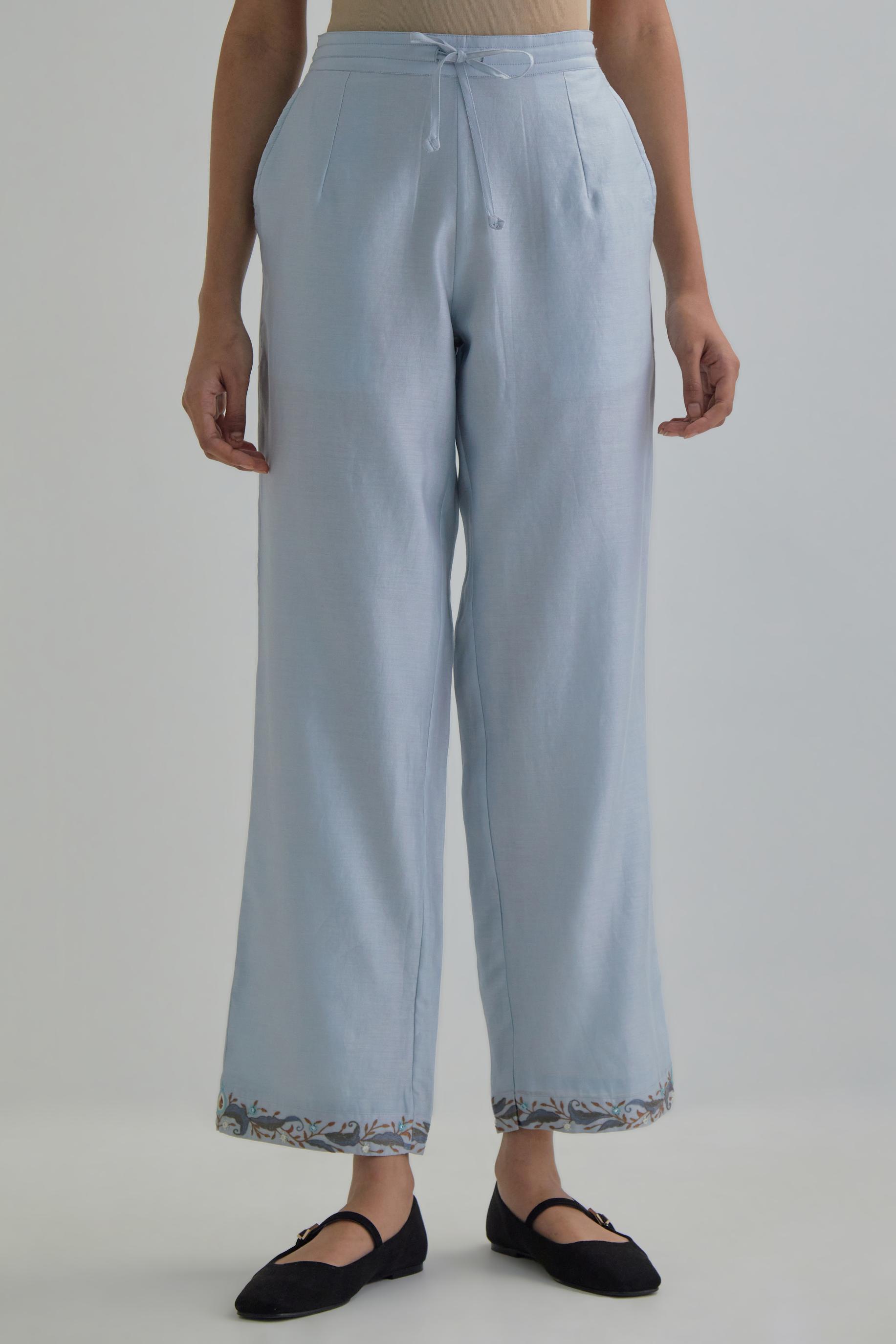 Blue silk Chanderi straight pants with earthy coloured Aari work at hem.