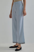 Blue silk Chanderi straight pants with earthy coloured Aari work at hem.