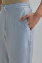 Blue silk Chanderi straight pants with earthy coloured Aari work at hem.