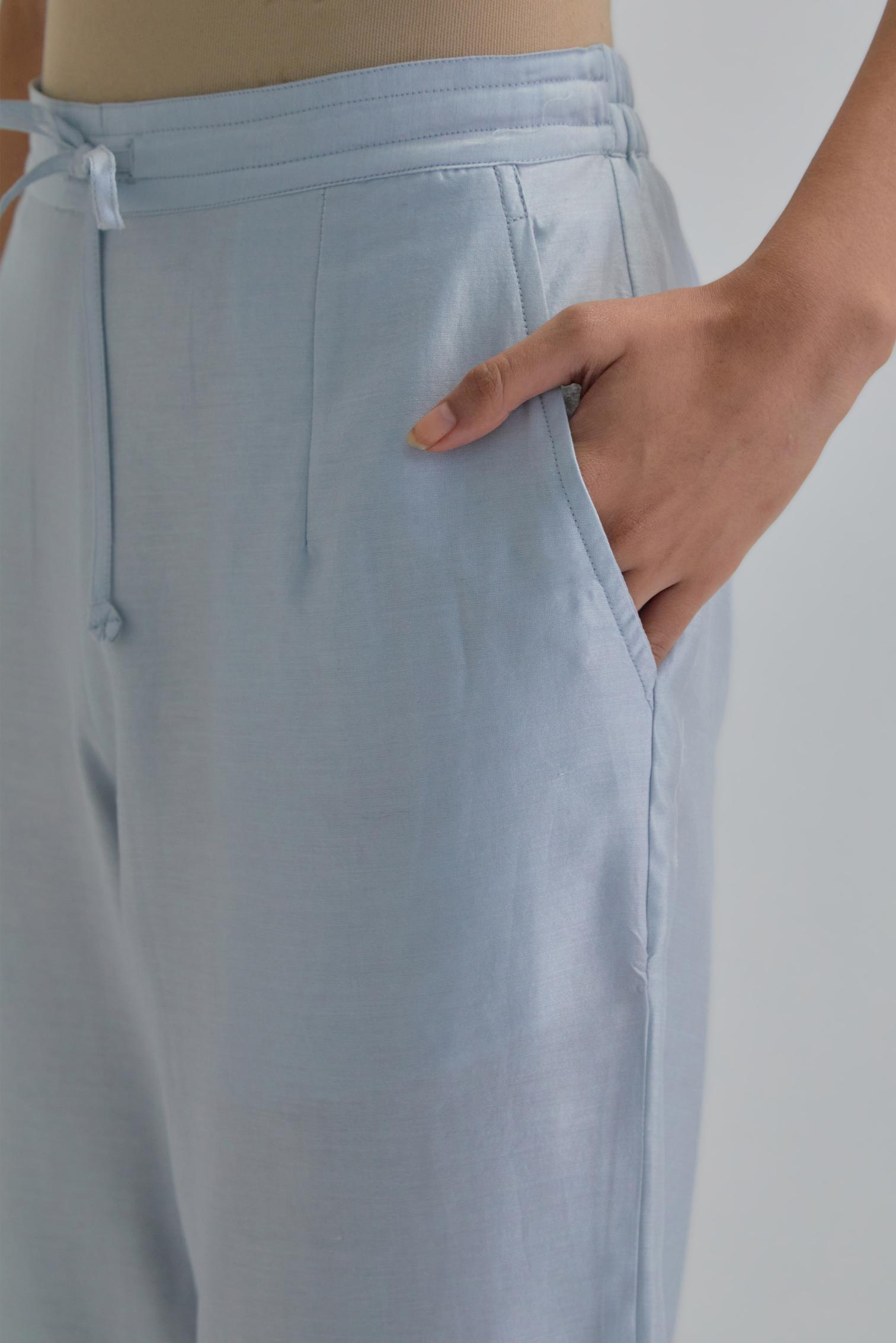 Blue silk Chanderi straight pants with earthy coloured Aari work at hem.