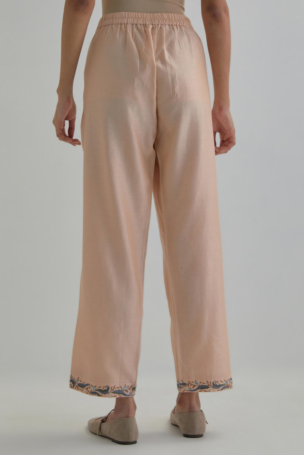 Pink silk Chanderi straight pants with earthy coloured Aari work at hem.