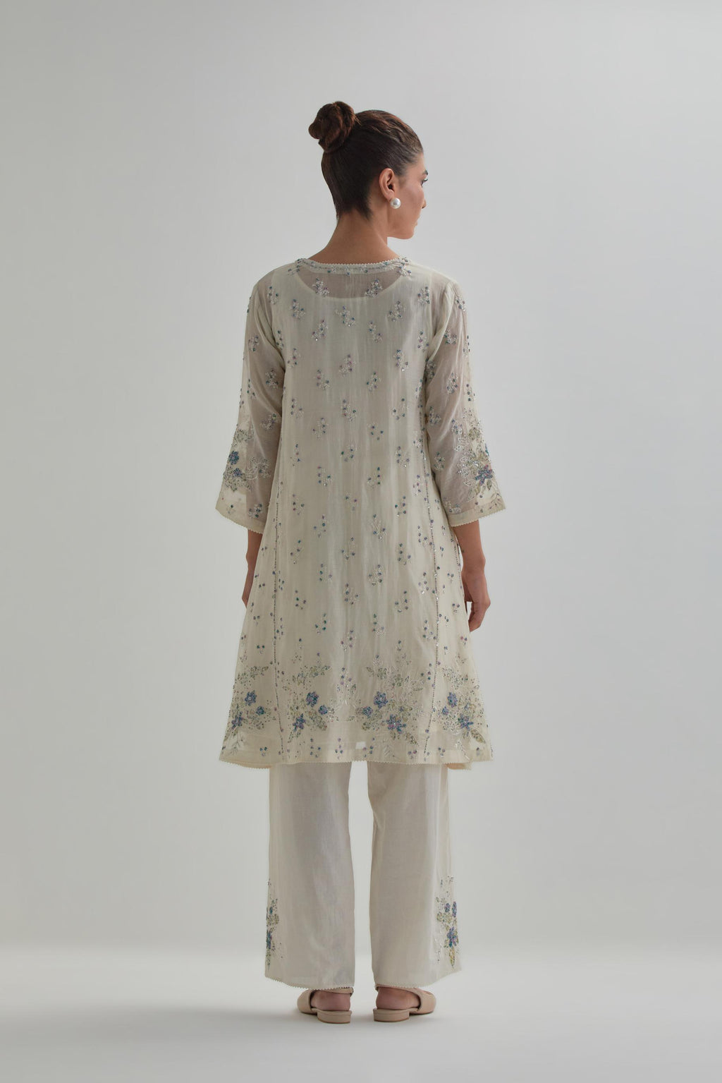 Off white cotton Chanderi short kalidar kurta set with all-over blue & beige hand block printed appliqué flowers, highlighted with sequins and multi coloured beads.