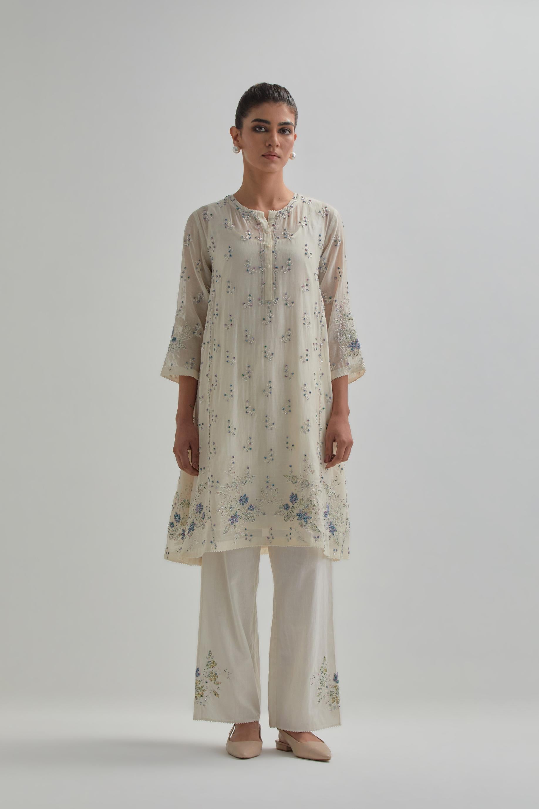 Off white cotton Chanderi short kalidar kurta set with all-over blue & beige hand block printed appliqué flowers, highlighted with sequins and multi coloured beads.