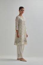 Off white cotton Chanderi short kalidar kurta set with all-over blue & beige hand block printed appliqué flowers, highlighted with sequins and multi coloured beads.