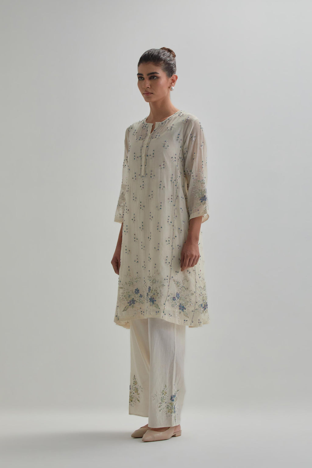 Off white cotton Chanderi short kalidar kurta set with all-over blue & beige hand block printed appliqué flowers, highlighted with sequins and multi coloured beads.