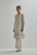 Off white cotton Chanderi short kalidar kurta set with all-over blue & beige hand block printed appliqué flowers, highlighted with sequins and multi coloured beads.