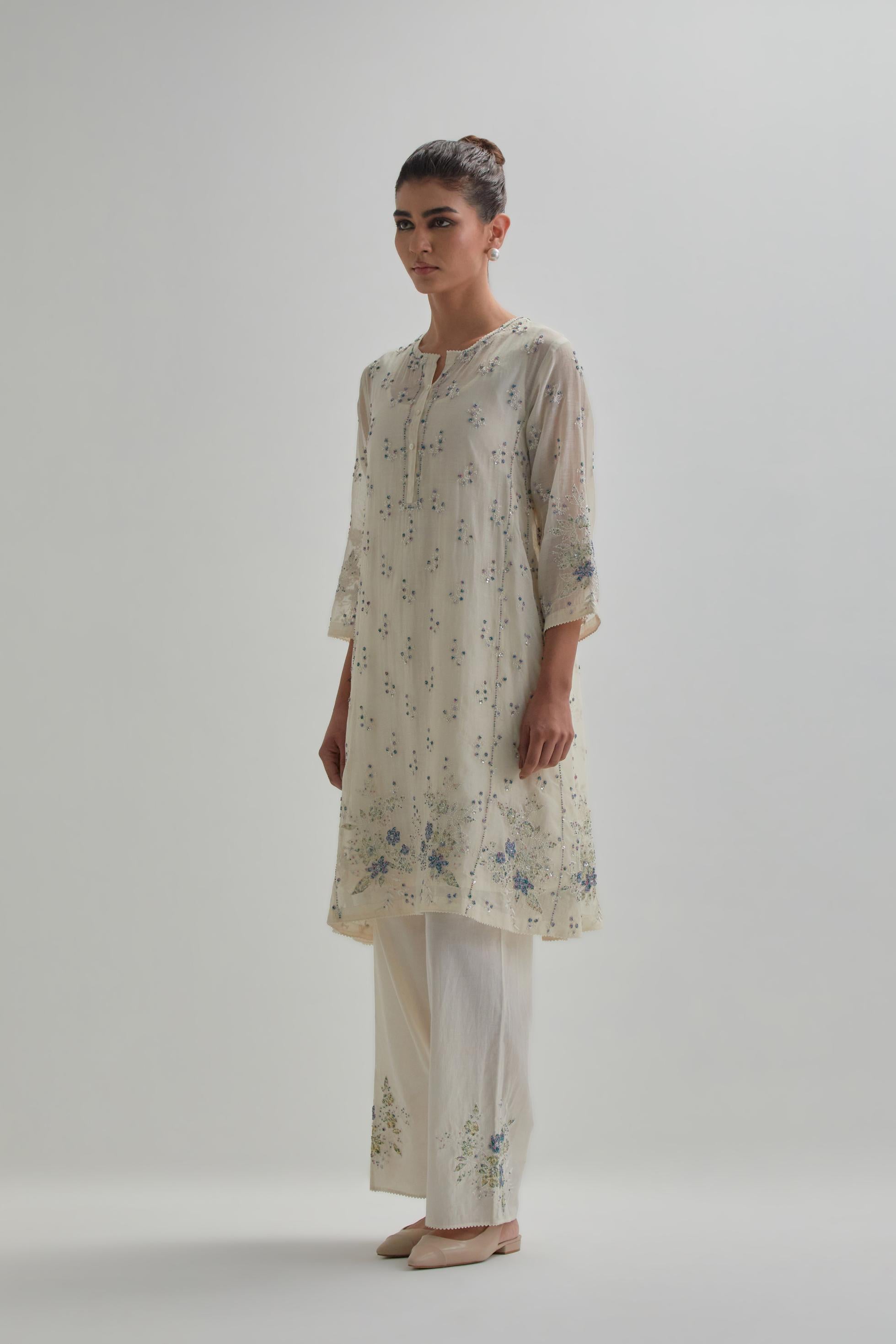 Off white cotton Chanderi short kalidar kurta set with all-over blue & beige hand block printed appliqué flowers, highlighted with sequins and multi coloured beads.