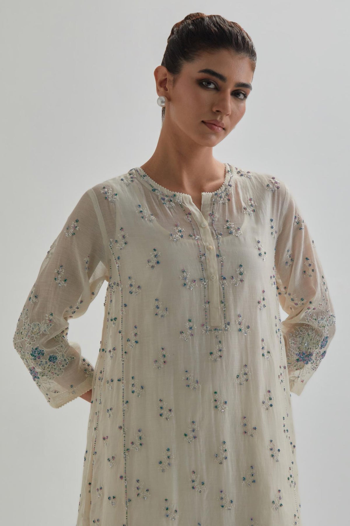 Off white cotton Chanderi short kalidar kurta set with all-over blue & beige hand block printed appliqué flowers, highlighted with sequins and multi coloured beads.