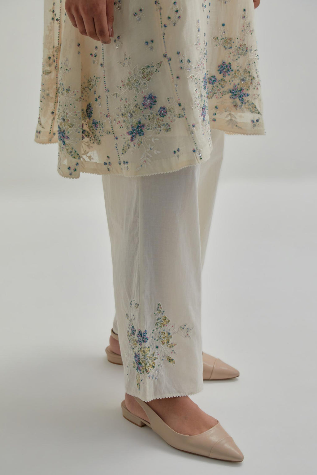 Off white cotton Chanderi short kalidar kurta set with all-over blue & beige hand block printed appliqué flowers, highlighted with sequins and multi coloured beads.