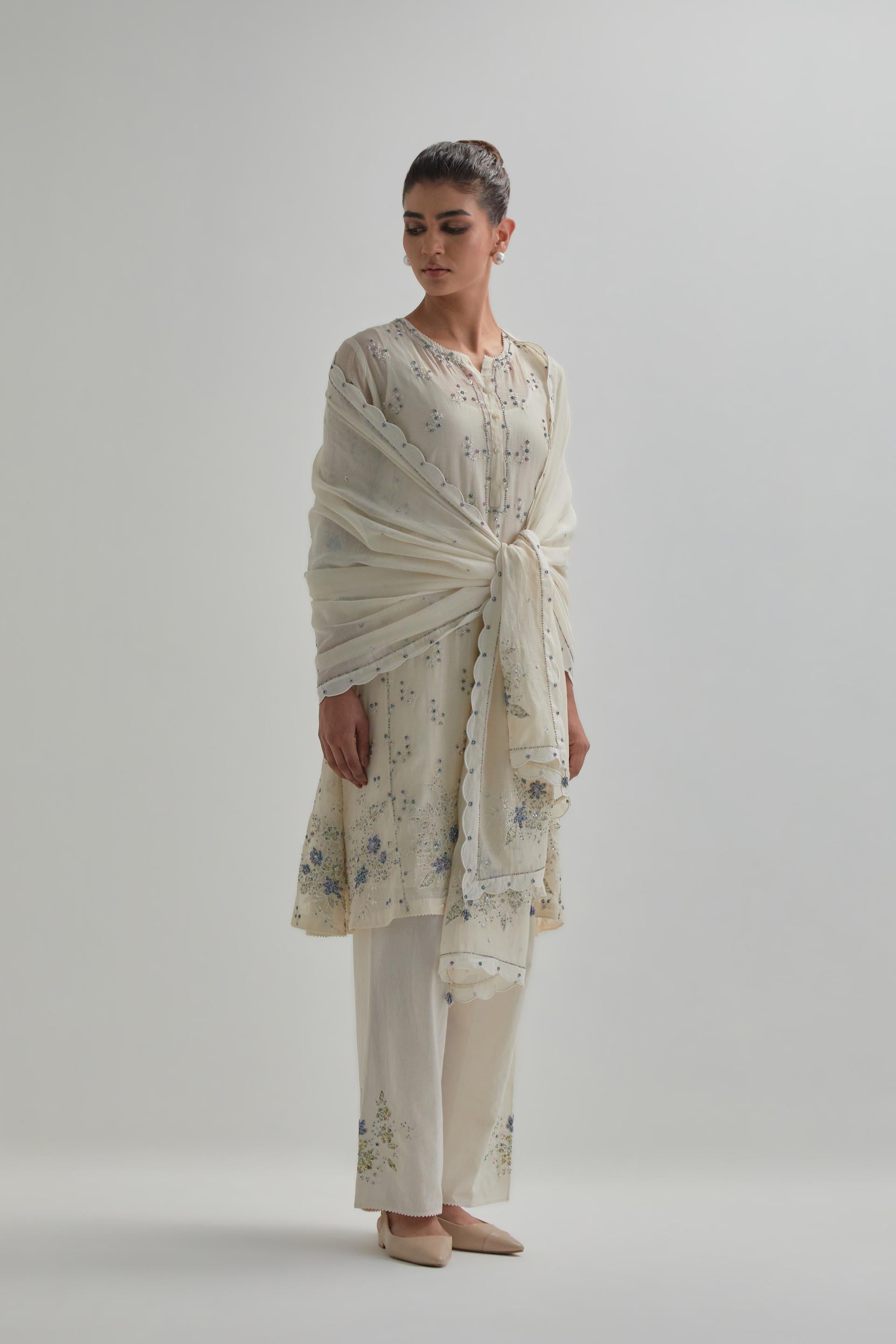 Off white cotton Chanderi short kalidar kurta set with all-over blue & beige hand block printed appliqué flowers, highlighted with sequins and multi coloured beads.