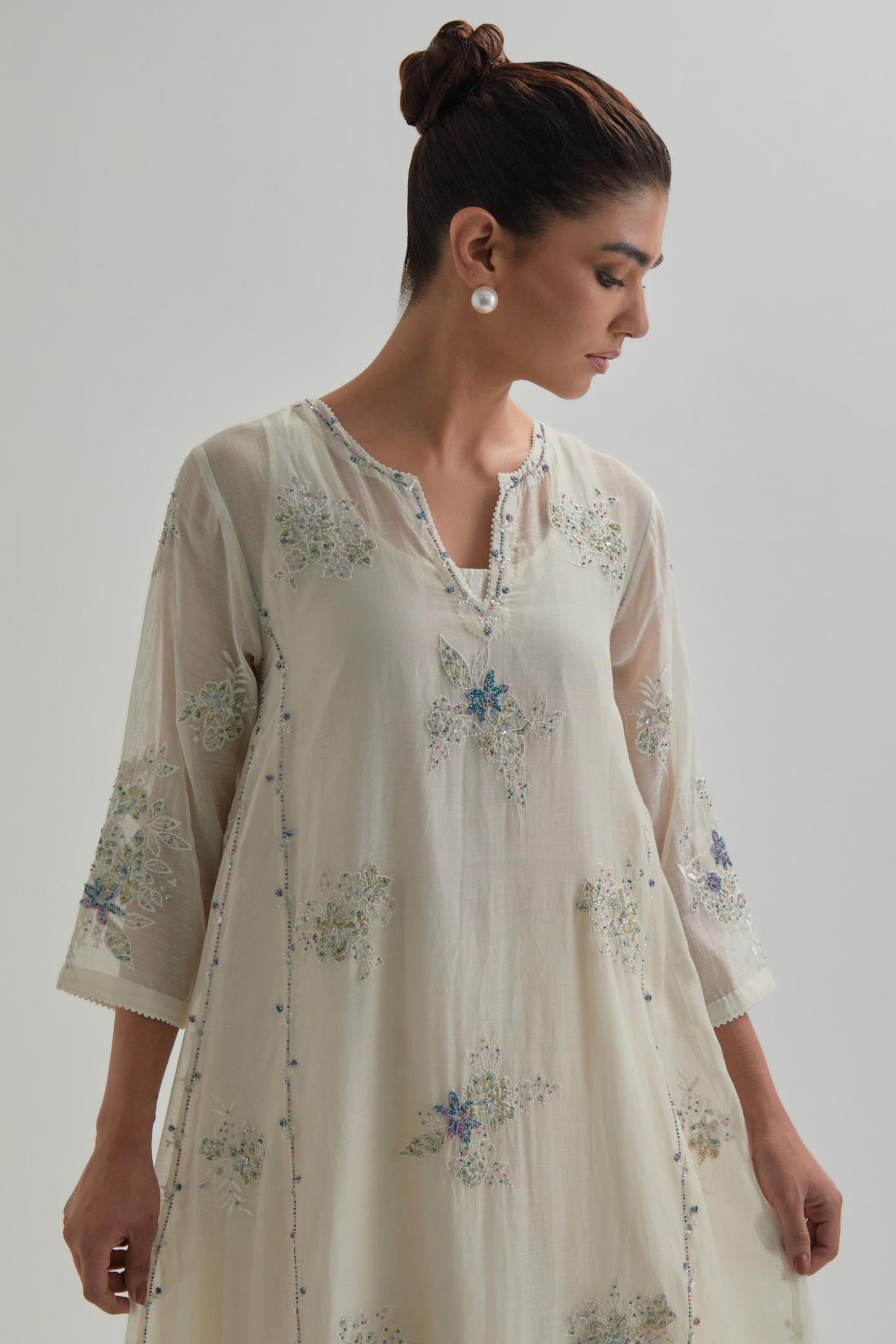 Off-white cotton Chanderi kurta set with asymmetric hem and all-over blue & beige hand block printed appliqué flowers.