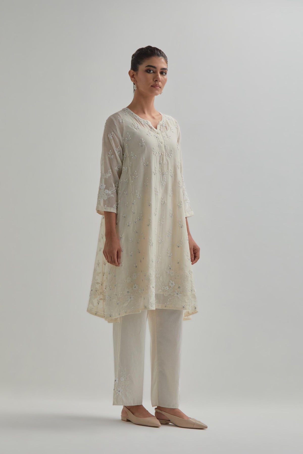 Off white cotton Chanderi short kalidar kurta set with all-over appliqué flowers, highlighted with sequins and beads.