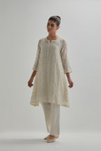 Off white cotton Chanderi short kalidar kurta set with all-over appliqué flowers, highlighted with sequins and beads.