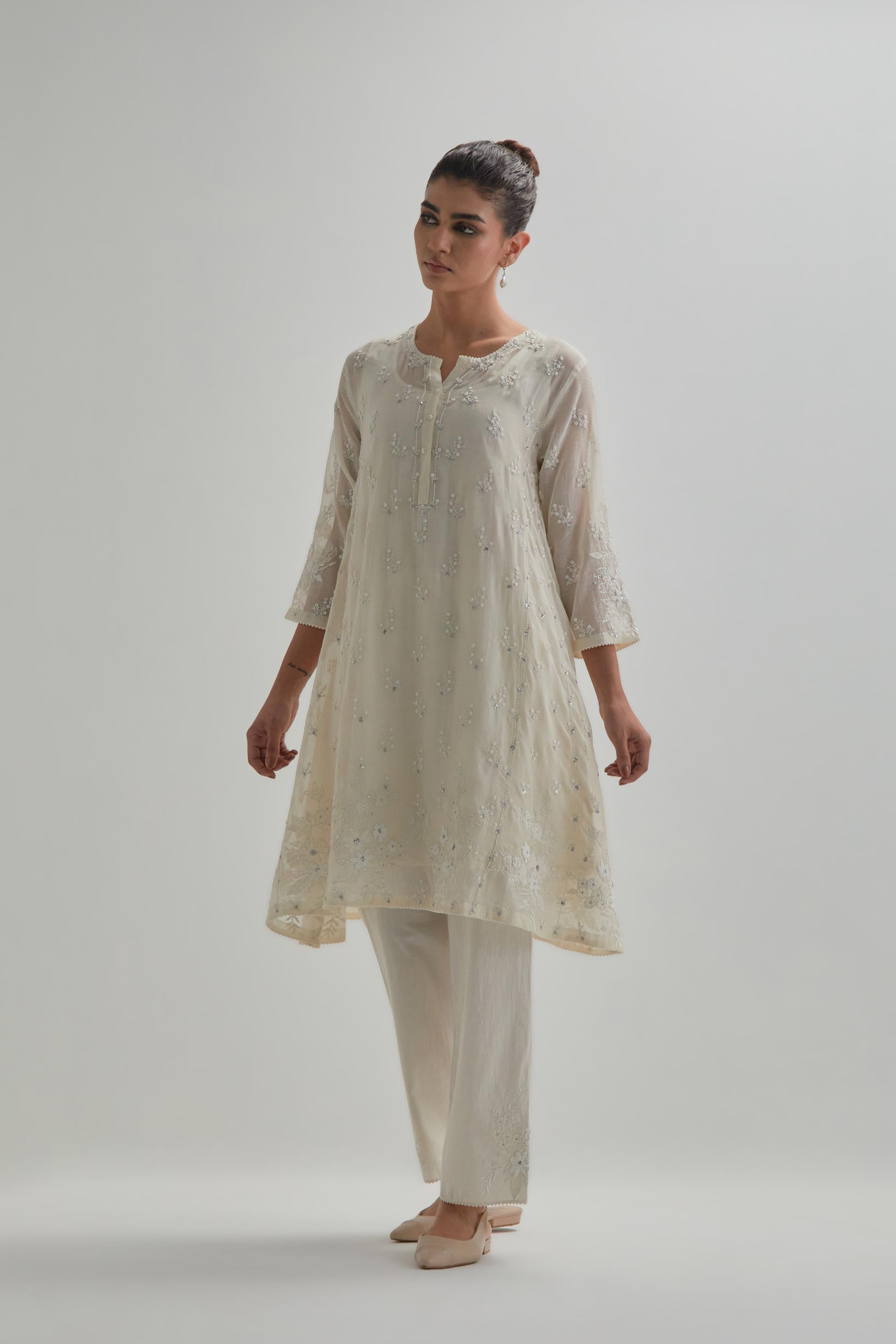 Off white cotton Chanderi short kalidar kurta set with all-over appliqué flowers, highlighted with sequins and beads.