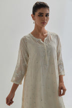 Off white cotton Chanderi short kalidar kurta set with all-over appliqué flowers, highlighted with sequins and beads.