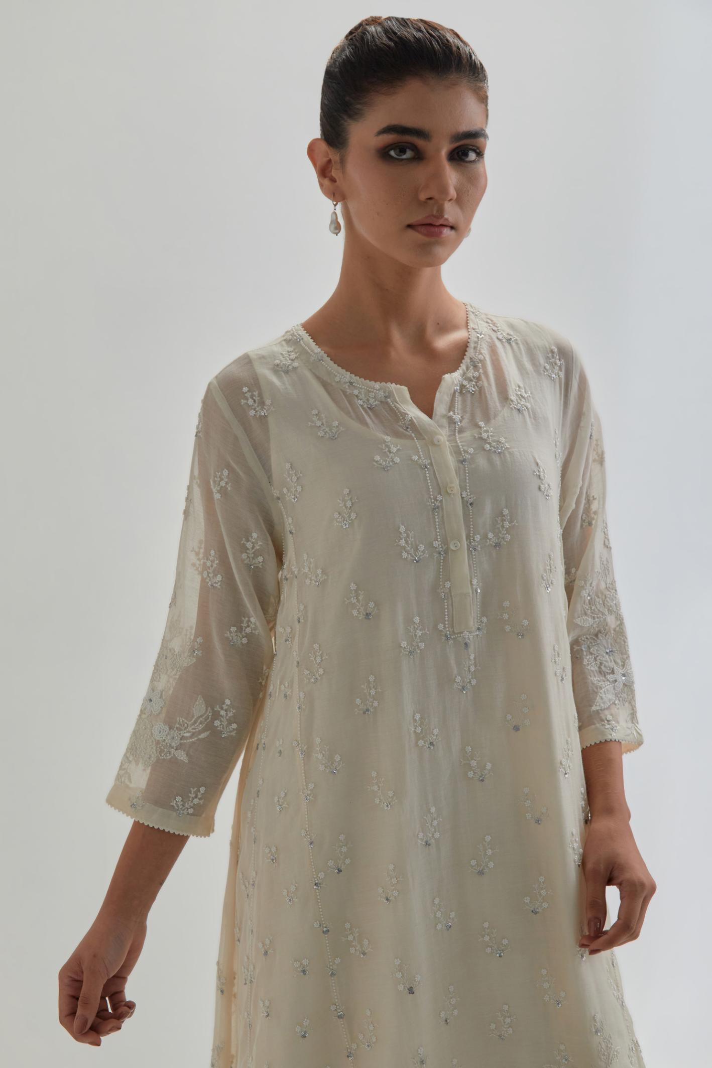 Off white cotton Chanderi short kalidar kurta set with all-over appliqué flowers, highlighted with sequins and beads.