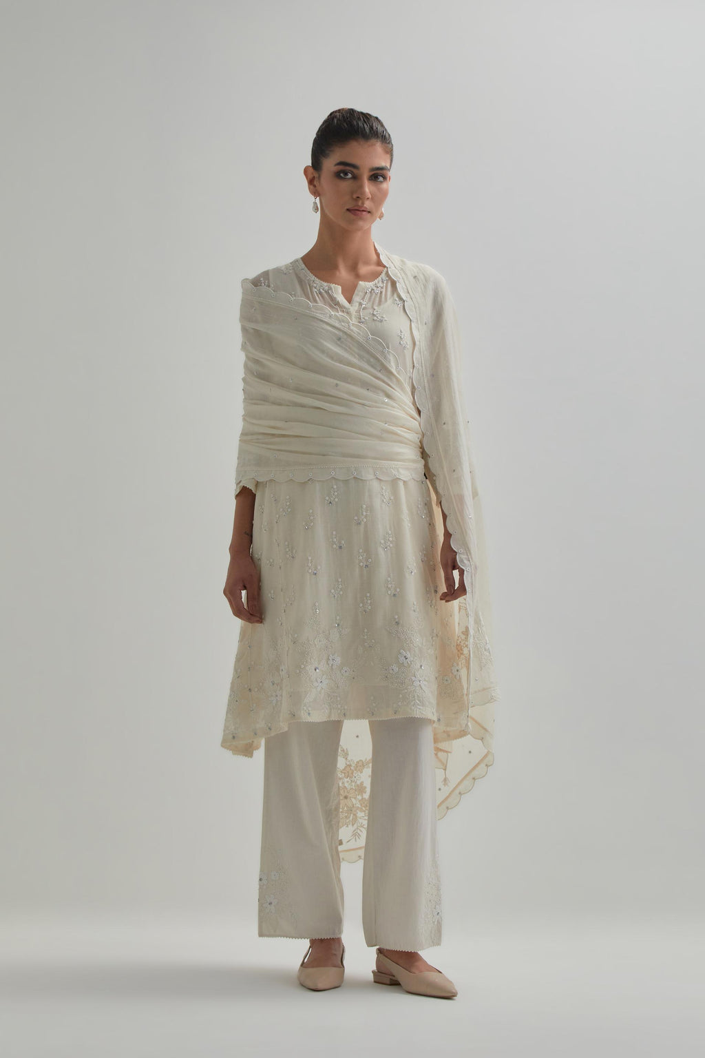 Off white cotton Chanderi short kalidar kurta set with all-over appliqué flowers, highlighted with sequins and beads.