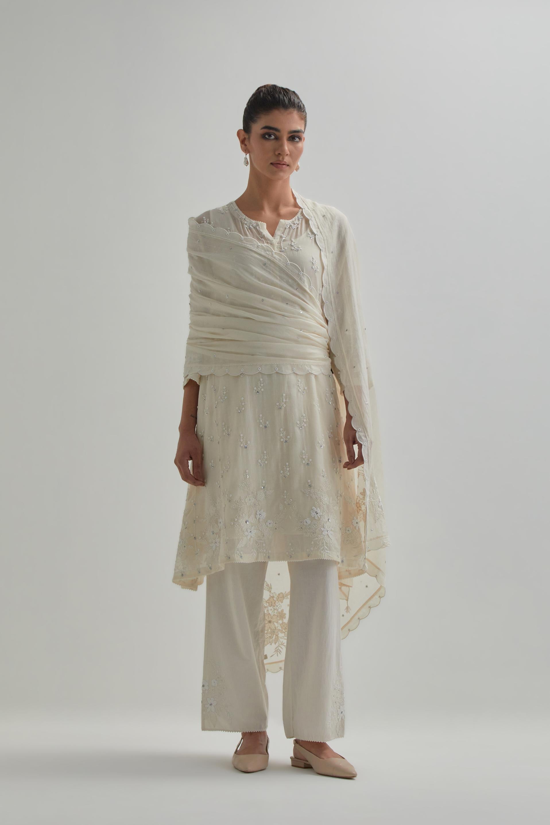 Off white cotton Chanderi short kalidar kurta set with all-over appliqué flowers, highlighted with sequins and beads.