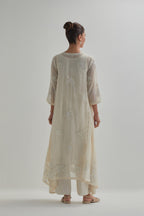 Off-white cotton Chanderi kurta set with asymmetric hem and all-over appliqué flowers, highlighted with sequins and beads.