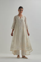 Off-white cotton Chanderi kurta set with asymmetric hem and all-over appliqué flowers, highlighted with sequins and beads.