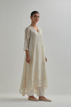 Off-white cotton Chanderi kurta set with asymmetric hem and all-over appliqué flowers, highlighted with sequins and beads.