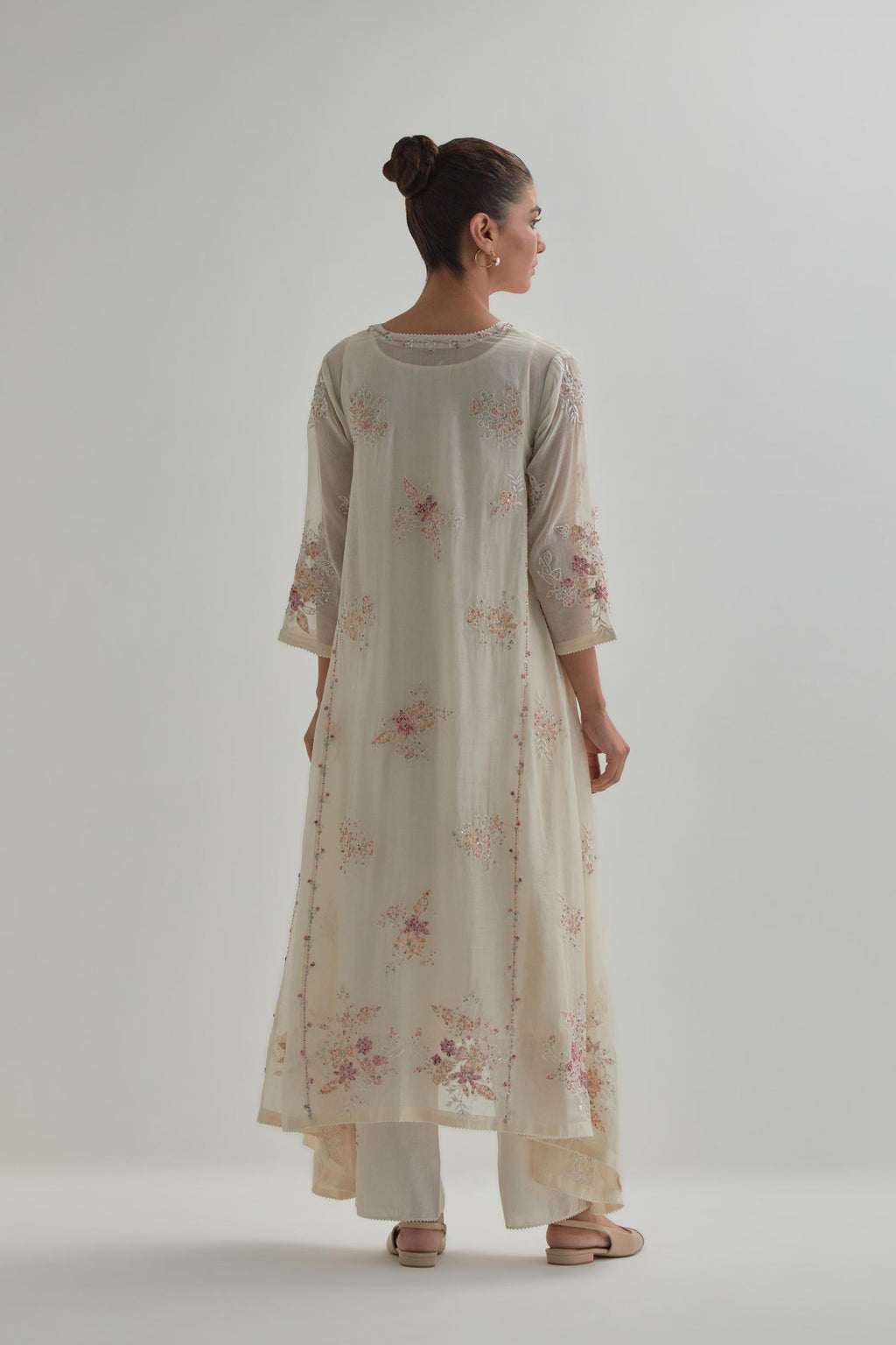 Off-white cotton Chanderi kurta set with asymmetric hem and all-over pink & beige hand block printed appliqué flowers.