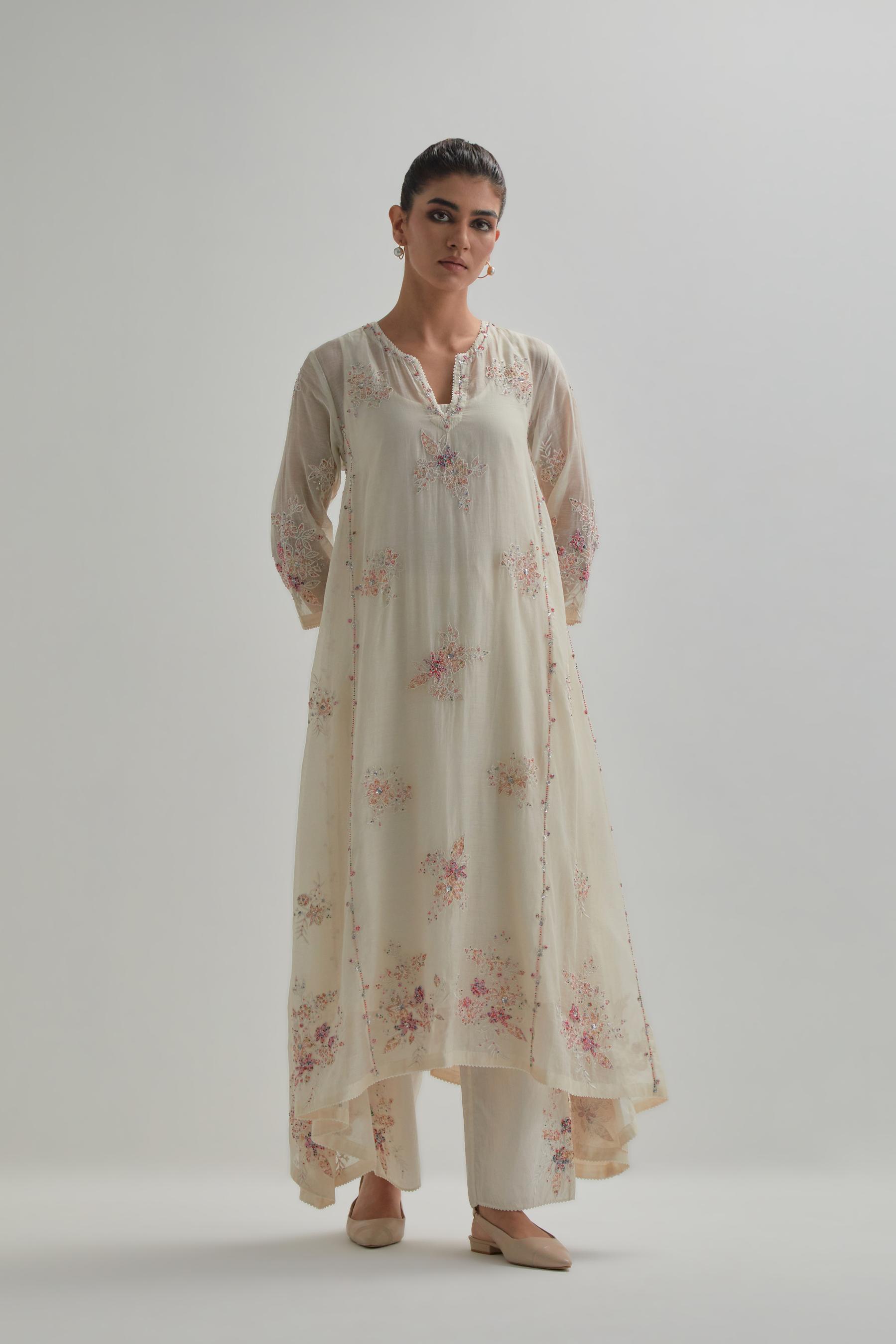 Off-white cotton Chanderi kurta set with asymmetric hem and all-over pink & beige hand block printed appliqué flowers.