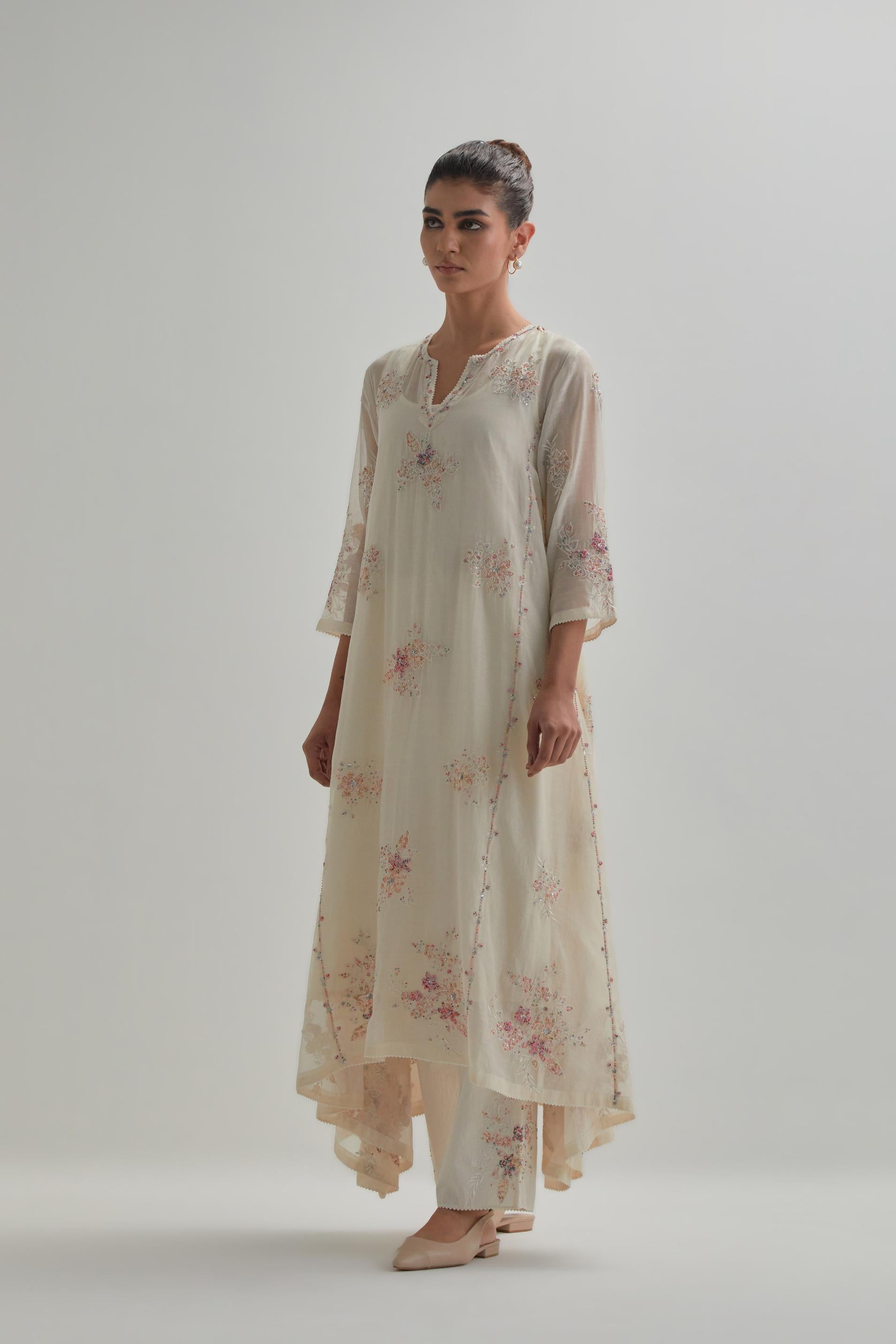 Off-white cotton Chanderi kurta set with asymmetric hem and all-over pink & beige hand block printed appliqué flowers.