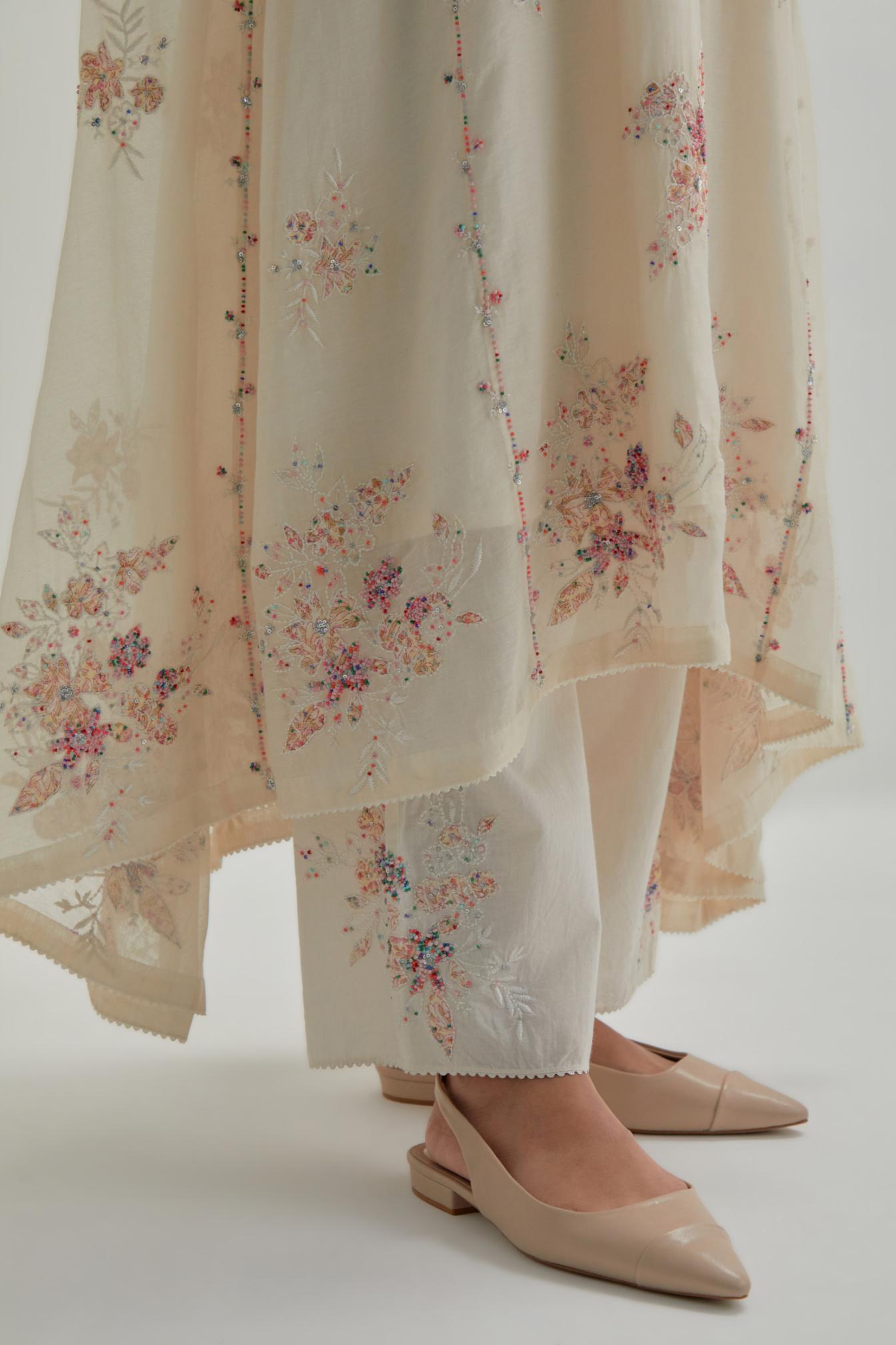 Off-white cotton Chanderi kurta set with asymmetric hem and all-over pink & beige hand block printed appliqué flowers.