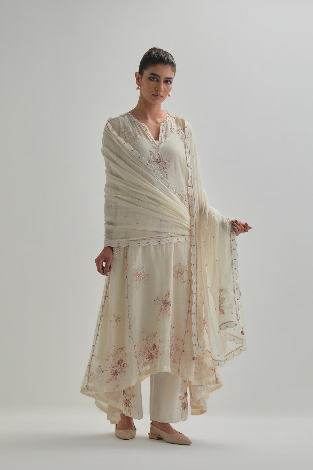 Off-white cotton Chanderi kurta set with asymmetric hem and all-over pink & beige hand block printed appliqué flowers.