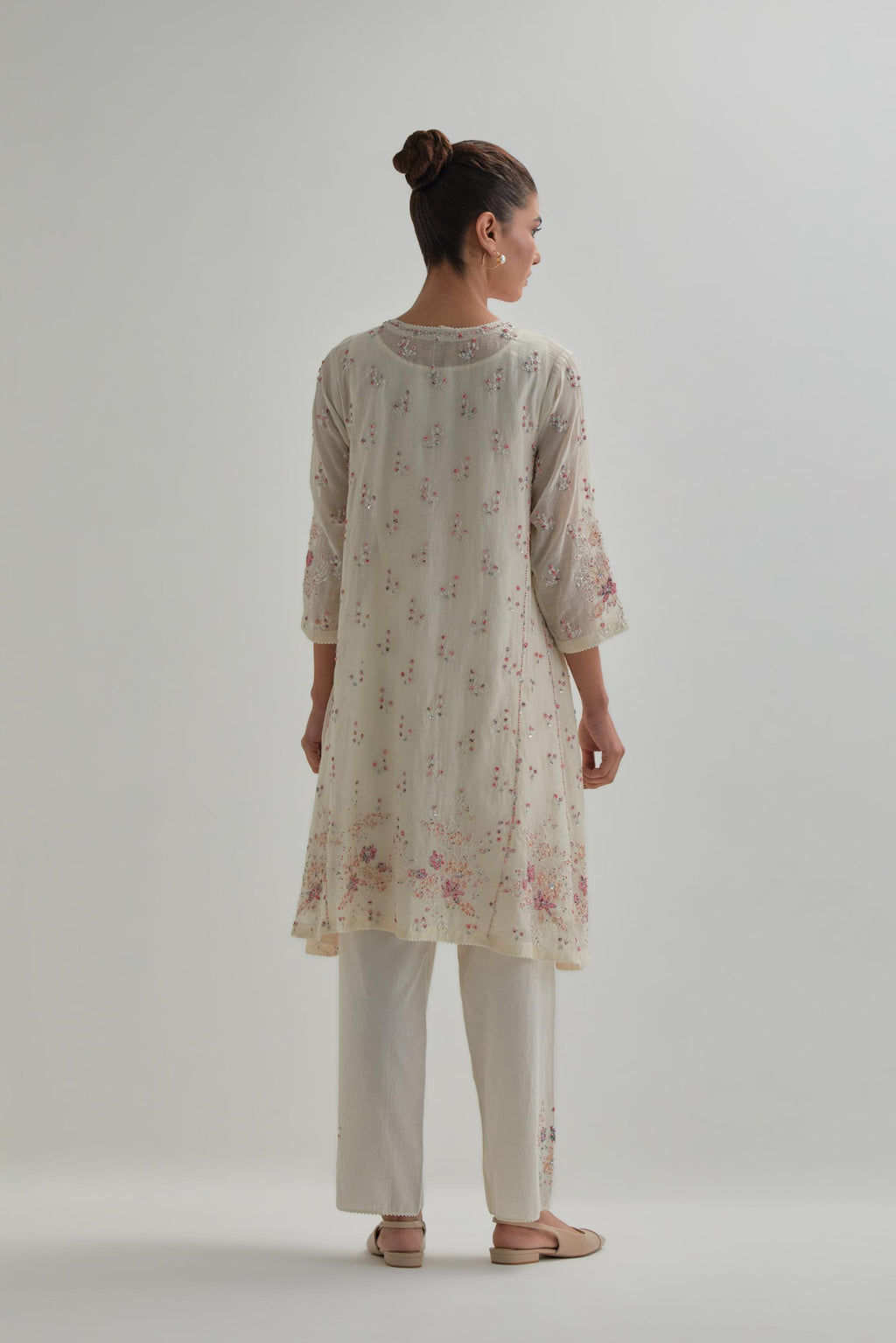 Off white cotton Chanderi short kalidar kurta set with all-over pink & beige hand block printed appliqué flowers, highlighted with sequins and multi coloured beads.