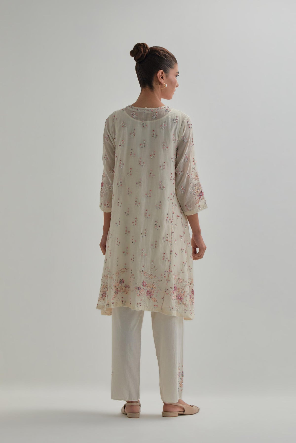 Off white cotton Chanderi short kalidar kurta set with all-over pink & beige hand block printed appliqué flowers, highlighted with sequins and multi coloured beads.