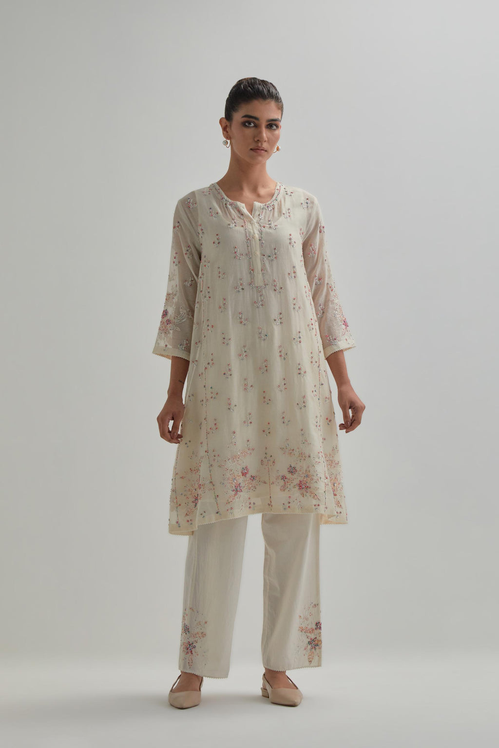 Off white cotton Chanderi short kalidar kurta set with all-over pink & beige hand block printed appliqué flowers, highlighted with sequins and multi coloured beads.
