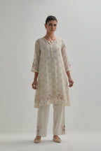 Off white cotton Chanderi short kalidar kurta set with all-over pink & beige hand block printed appliqué flowers, highlighted with sequins and multi coloured beads.