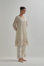 Off white cotton Chanderi short kalidar kurta set with all-over pink & beige hand block printed appliqué flowers, highlighted with sequins and multi coloured beads.